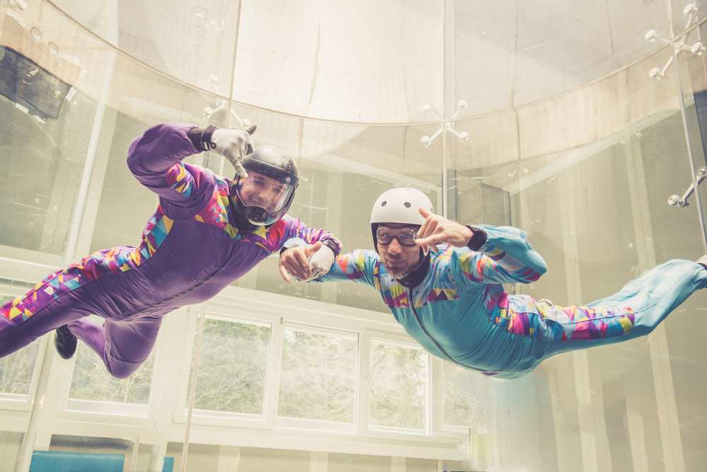 Man experiencing indoor skydiving with instructor