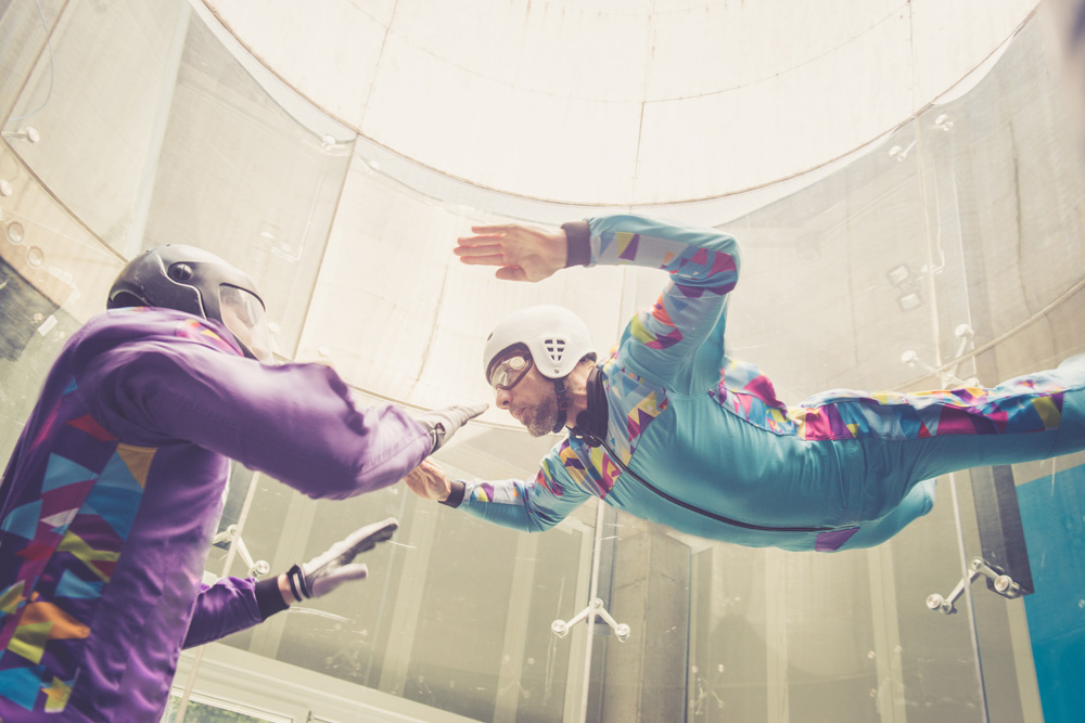 Man experiencing indoor skydiving with instructor